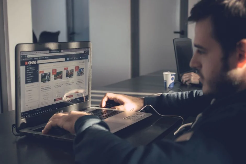 Un espace de création avec des maquettes d’interface, des crayons, un smartphone et d’autres outils de bureau.